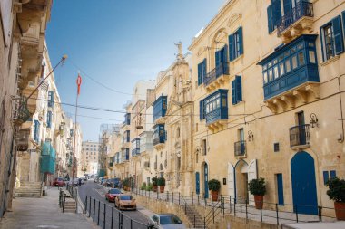 Valletta, Malta 'nın merkezinde eski mimarisi ve mavi balkonları olan büyük bir cadde.
