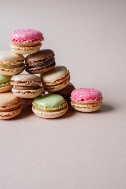 Bej arkaplanda çok renkli badem kurabiyelerinden yapılmış piramit