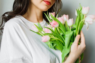 Genç esmer kadının ellerinde pembe lale buketi. Yaklaş.