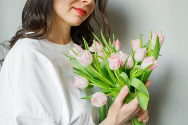 Genç esmer kadının ellerinde pembe lale buketi. Yaklaş.