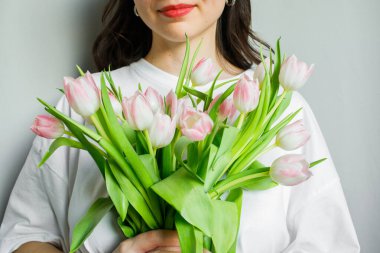 Pembe laleler genç bir bayanın ellerinde.