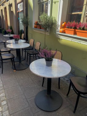 Şehir kafe masaları, kenevir ve balkabaklarıyla süslenmiş sonbahar tarzında dışarıda duruyor.