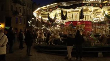 İnsanlar eski Venedik atlıkarıncalarına biniyor ve Noel 'den önce Poznan, Polonya' daki Eski Pazar meydanında