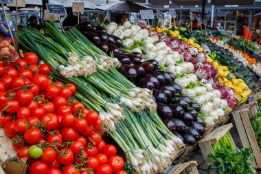 İyi organize edilmiş ve gıda pazarında sunulan farklı sebzeler. Domates, soğan, patlıcan ve diğer sağlıklı sebzeler. Kopenhag, Danimarka 'da Torvehallerne gıda pazarı..
