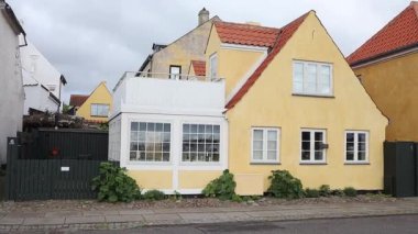 Danimarka 'nın Dragor kasabasında küçük sarı geleneksel evleri olan bir sokak.