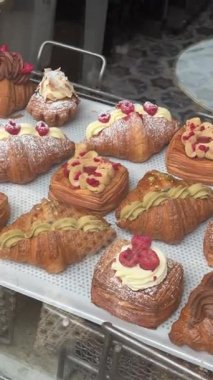 Pencerenin arkasındaki bir kafede Danimarka çöreği: sokaktan manzara. Danimarka, Kopenhag 'daki bir fırında lezzetli çörekler ve kruvasanlar.