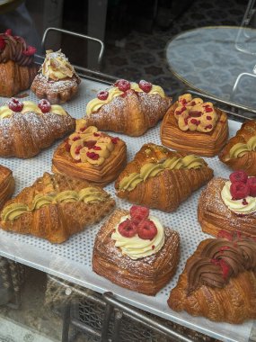 Pencerenin arkasındaki bir kafede Danimarka çöreği: sokaktan manzara. Danimarka, Kopenhag 'daki bir fırında lezzetli çörekler ve kruvasanlar.