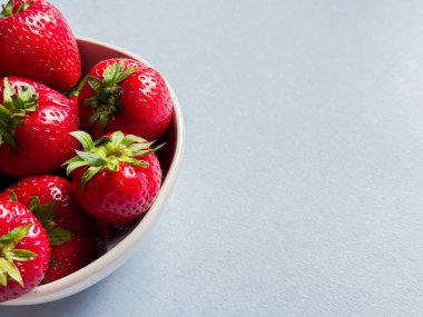 Mavi arka plan görünümlü çilekli kase