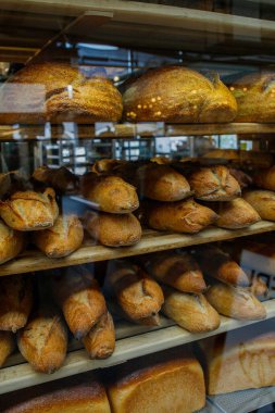 Ekmek kredileri ve ekmeklerle dolu cam fırın vitrini. Kopenhag, Danimarka 'daki Torvehallerne gıda pazarı binası.