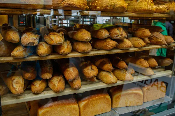 Ekmek kredileri ve ekmeklerle dolu cam fırın vitrini. Kopenhag, Danimarka 'daki Torvehallerne gıda pazarı binası.