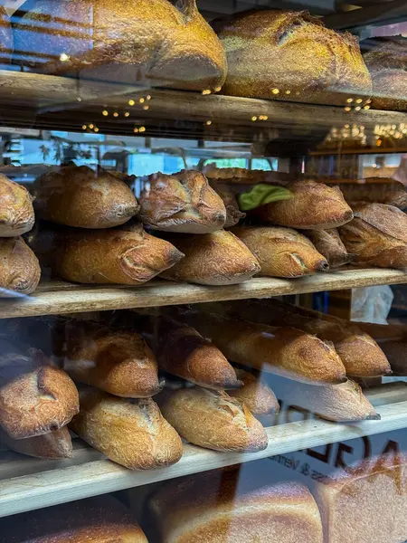 Ekmek kredileri ve ekmeklerle dolu cam fırın vitrini. Kopenhag, Danimarka 'daki Torvehallerne gıda pazarı binası.