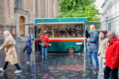 Danimarka 'nın Kopenhag şehrinde geleneksel Danimarka sosislileriyle dolu bir yemek kamyonu. İnsanlar DOP sokak gıda şirketinin popüler sosislilerini satın alıyor.