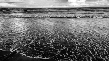 Wave and sandy beach in black and white. Calm view during sunset at Pantai Anak Air, Kuantan Pahang, Malaysia. clipart