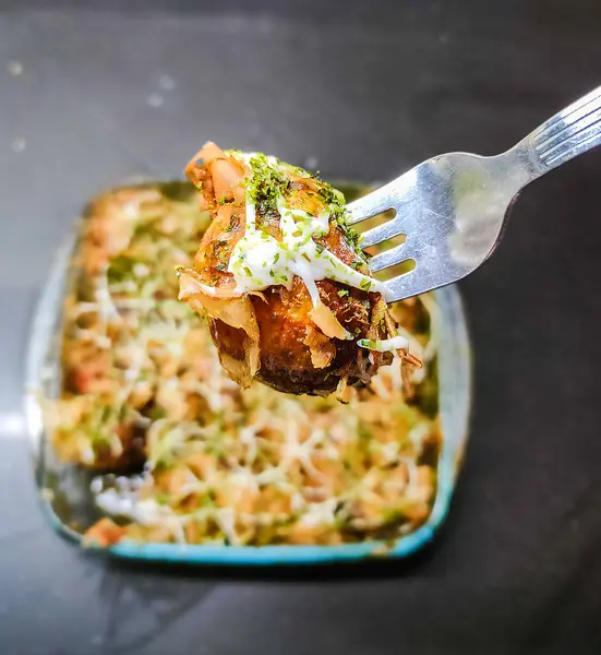 Takoyaki, ahtapot topları, Japon yemekleri, bulanık siyah arka planda.
