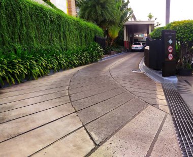 The entrance of the Grand Hyatt Hotel in downtown on MH Thamrin street. Several cars have just arrived at the hotel lobby.Jakarta, Indonesia, June 23, 2024. The uphill road leading to the hotel lobby is decorated with beautiful green plants. clipart