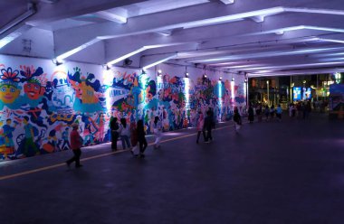 Kendal Tüneli yumuşak ve güzel mavi neon ışıklarla süslenmiş. Kendal Tüneli, Jakarta, gece. Birçok insan Sudirman KRL istasyonuna doğru yürüyor ve gidiyor. Endonezya, 23 Haziran 2024.