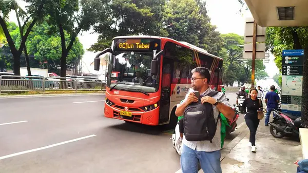 Yayalar Casablanca caddesindeki bir otobüs durağına vardılar ve alışveriş alanına doğru yürüyorlar. Bir Transjakarta minibüsü az önce yolcuları otobüs durağına bıraktı. Jakarta, Endonezya, 21 Mayıs 2024.