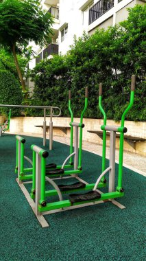 Egzersiz aracı olarak hava yürüyüşçüleri ve açık hava bisikletleri. Konut bahçesinin kenarında bulunan ve yoğun ve yumuşak çakıl dokusundan yapılmış fayanslarla kaplı spor malzemeleri..