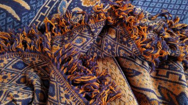 Renkli püskülleri ve çeşitli motifleri olan Güneydoğu Asya etnik dokuma kumaşları yığını ve katları. Güzel püsküllü, çiçekli, elmaslı ve çizgili geleneksel kumaşlar..