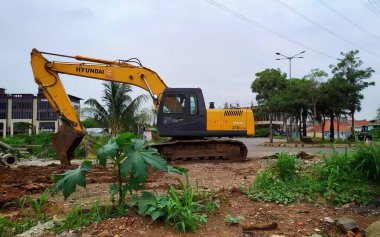 Kazıcı adı verilen ağır bir ekipman bir inşaat projesinde. Kırmızı toprak tarlası inşaatın ortasında. Jakarta, Endonezya, 9 Ocak 2025.