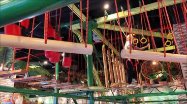 İki çocuk tırmanma alanındalar, oyun oynamayı ve dikkatli yürümeyi seviyorlar. Eğlence alanında güvenlik için kask takıyorlar ve başlık takıyorlar. Jakarta, Endonezya, 6 Nisan 2025.