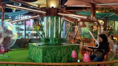 Çocuklar ve aileleri lunaparkta uçan bir atlıkarınca bisikletine binerek eğleniyorlar ve heyecanlılar. Eğlence Dünyası Maceraları 'nda pervaneli bisikletle uçmak. Jakarta, Endonezya, 6 Nisan 2025.