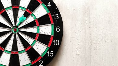 Dartboard yıpranmış bir duvarda asılı. Hedef oyun. Sık kullanılan oyunlardan kalma küçük delikleri olan dartboard. Dart tahtasının dokusu ve arkaplanı.