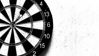 Dartboard yıpranmış bir duvarda asılı. Hedef oyun. Sık kullanılan oyunlardan kalma küçük delikleri olan dartboard. Dart tahtasının dokusu ve arkaplanı.