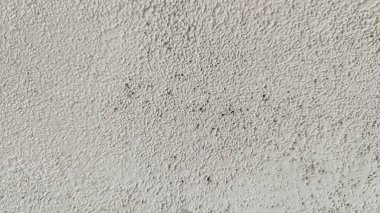 Beton ve taş parçalarının kuru yapraklar ve dallarla karıştırılmış bulanık görüntüsü. Tırtıklı yüzeyler ve pürüzlü dokular duvar yıkımını ya da çöküşünü gösteriyor.