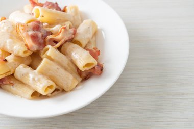 Beyaz soslu ve pastırmalı ev yapımı spagetti rigatoni makarna. İtalyan usulü.