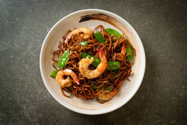 Kızarmış yakisoba eriştesi, yeşil bezelye ve karides, Asya usulü.