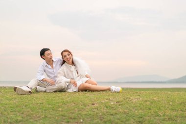 Happy young Asian couple in bride and groom clothing ready for marry and wedding celebrate