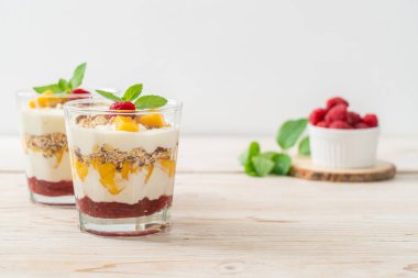 Ev yapımı taze mango ve yoğurt ve granola ile taze ahududu. Sağlıklı yemek tarzı.