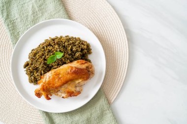 Kızarmış pesto pilavı ve beyaz tabakta kızarmış tavuk.