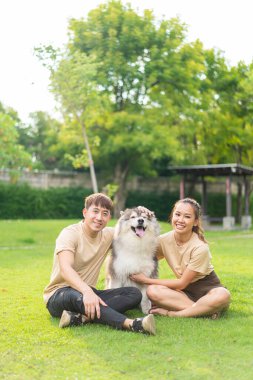 Asian couple love with cute dog in garden