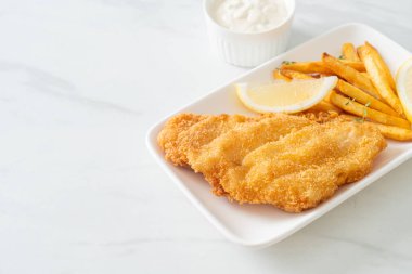 balık ve patates kızartması - kızarmış balık fileto patates cipsi ve limonlu beyaz tabak