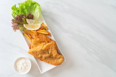 balık ve patates kızartması - kızarmış balık fileto patates cipsi ve limonlu beyaz tabak