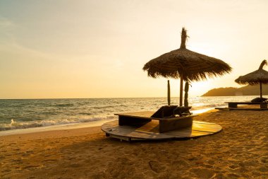 beach chair and umbrella with sea beach background at sunset time - Holidays and vacation concept