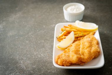 balık ve patates kızartması - kızarmış balık fileto patates cipsi ve limonlu beyaz tabak