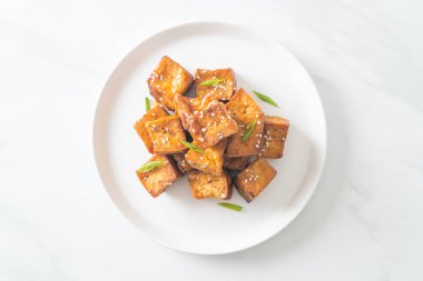 Beyaz susamlı kızarmış tofu ve teriyaki sosu. Vejetaryen ve vejetaryen yemek tarzı.