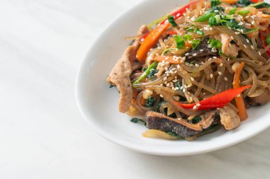 Japchae ya da karışık Kore vermicelli erişte sebzeli ve üzerine beyaz susamlı domuz eti - Kore geleneksel yemek tarzı