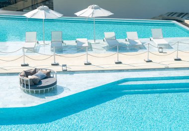 Yüzme havuzu etrafında yatak havuzu olan şemsiye - tatil ve tatil konsepti