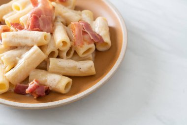 Beyaz soslu ve pastırmalı ev yapımı spagetti rigatoni makarna. İtalyan usulü.