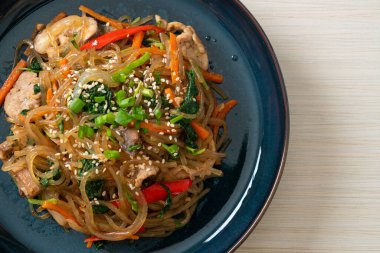 Japchae ya da karışık Kore vermicelli erişte sebzeli ve üzerine beyaz susamlı domuz eti - Kore geleneksel yemek tarzı