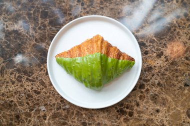 Taze kibrit yeşil çay kruvasan beyaz tabakta