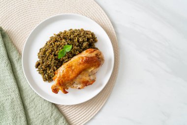 Kızarmış pesto pilavı ve beyaz tabakta kızarmış tavuk.