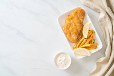 balık ve patates kızartması - kızarmış balık fileto patates cipsi ve limonlu beyaz tabak