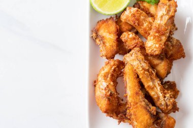 Fried Snapper Belly on white plate - Asian food style