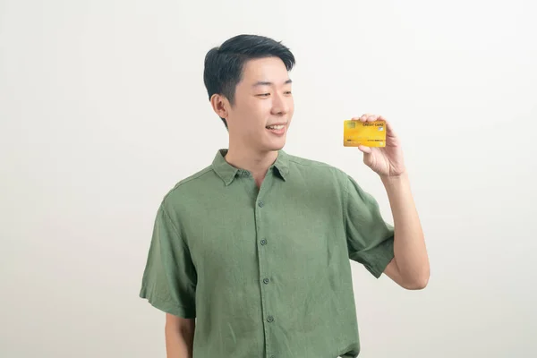 stock image portrait young Asian man holding credit card on white background