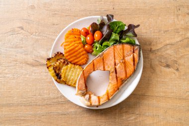 Kızarmış somon bifteği fileto, sebze ve patates kızartması.